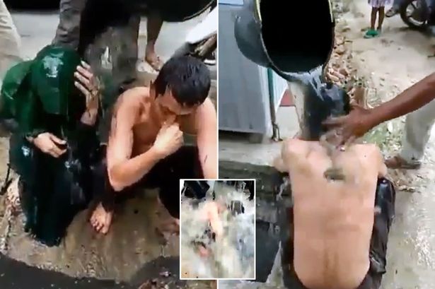 Half naked couple have bucket of raw sewage poured over them for having se
