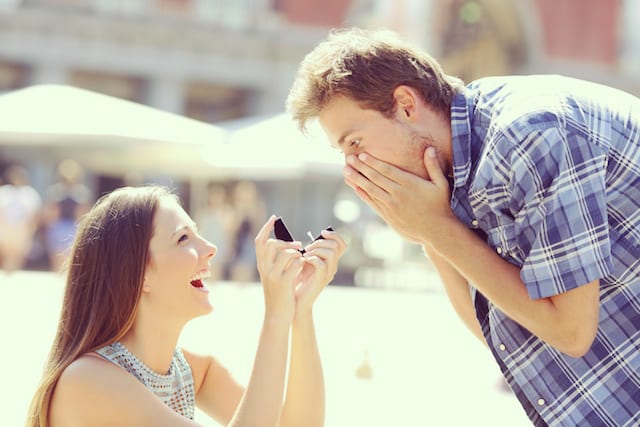 Proposal of a woman asking marry to a man in the middle of a street