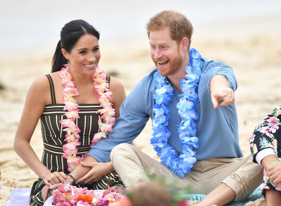 Meghan cradles her baby bump on Sydney beach and wears £880 maxi dress before she and Harry kick off their shoes to join an 'anti-bad vibes circle' with surfing mental health group