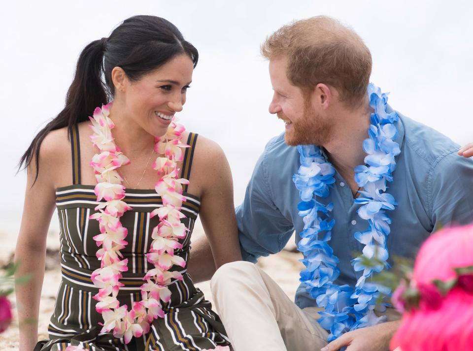 Meghan cradles her baby bump on Sydney beach and wears £880 maxi dress before she and Harry kick off their shoes to join an 'anti-bad vibes circle' with surfing mental health group