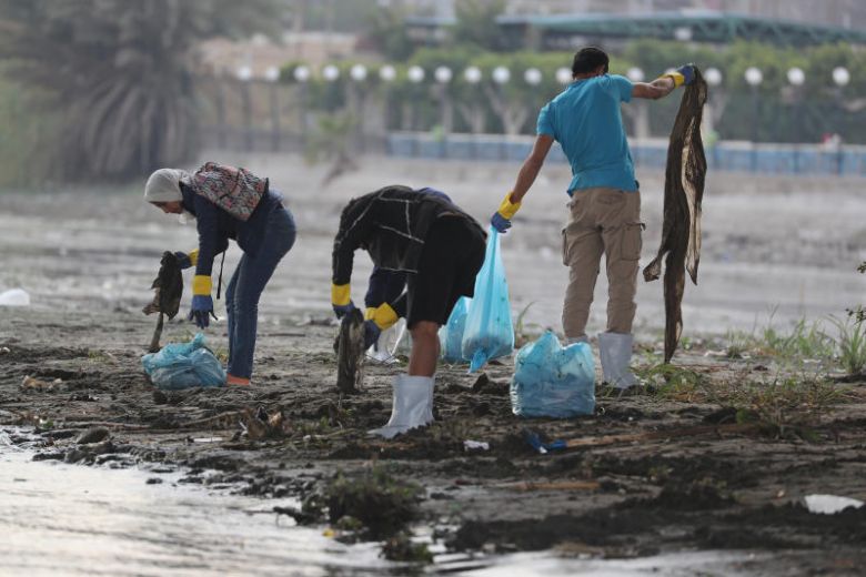 A volunteer collects waste and plastic as part of a campaign to clean up the Nile River, in Cairo