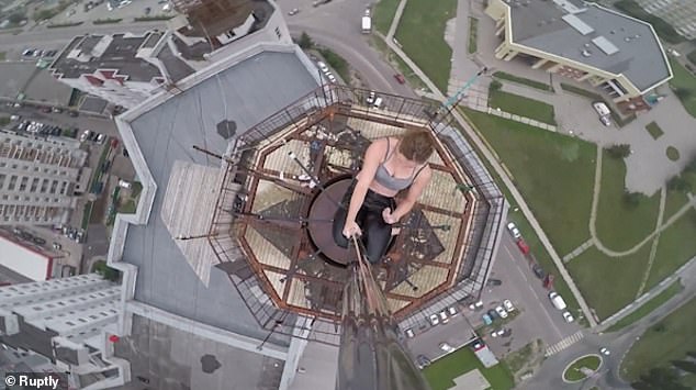 She's ruining the signal! Russian pole dancer performs a death-defying routine using the AERIAL of a Russian city centre skyscraper