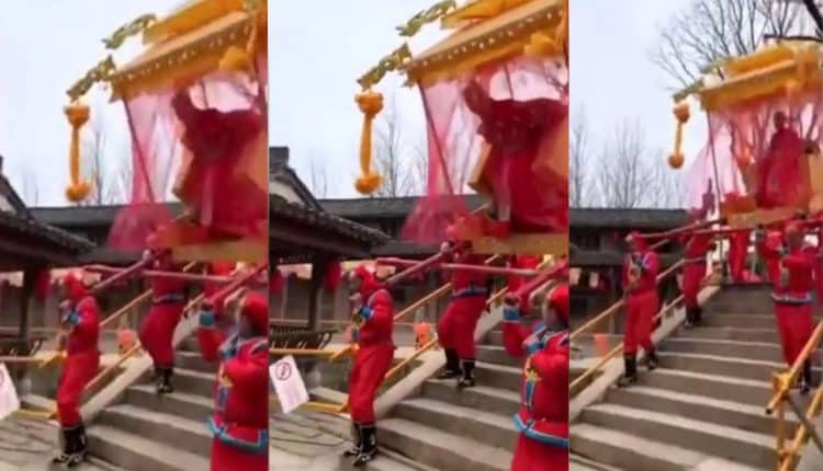 Woman tumbles out of sedan chair going downhill over bridge
